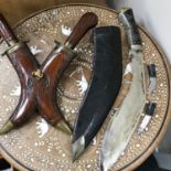 A horn handled Kukri knife with sheath and two small knives together with an Indian carver set