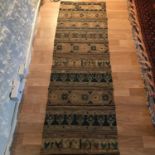 An antique hand woven rug, Done in the style of a sampler. Measures 96x63cm