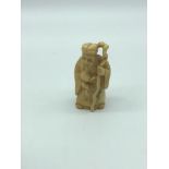 An antique hand carved ivory netsuke of an old man with cane. Signed by the artist. possibly meiji
