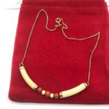 An antique 9ct gold choker necklace designed with ivory and coral beads.