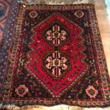 An antique Persian hand made rug. Measures 152x120cm