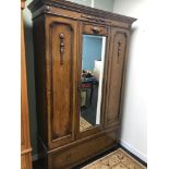 A 1920's Arts & Crafts dark oak mirror front wardrobe with one under drawer. Measures 200x126x47cm