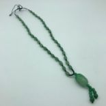 A jade necklace with carved pendant.