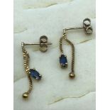 A Pair of 9ct gold droplet earrings set with Sapphire stones.