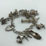 A Silver charm bracelet & twelve various silver charms.