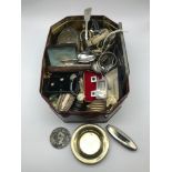 A tin full of interesting collectables, includes vintage watches, cuff links, coins, silver wares