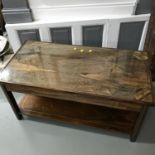 A Rosewood two tier coffee table with brass inalys and glass top. Measures 49x100x51cm