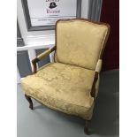 A Large reproduction lounge arm chair with gold material upholstery