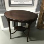 A mahogany oval two tier window table. Measures 73x77x52cm