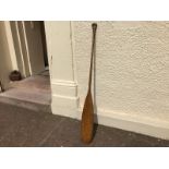 An antique oak canoe paddle with shaped handle