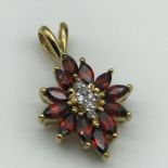 Gold Pendant designed with diamonds and Garnets.