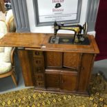 Early 1900's Singer sewing machine within a flame oak wood cabinet, fitted with drawers, Comes