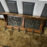 An Antique Solid oak wall hanging coat rack fitted with two bar scene panels.