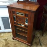A Victorian mahogany music cabinet designed with a mirror and carved panel door. On original