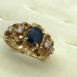 An 18ct gold or higher grade unusual set ring, One large centred Sapphire stone off set by 4