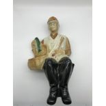 Vintage 1969 porcelain decanter shaped in the form of a seated fisherman, maker Ballantines Liquor