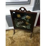 An Edwardian Mahogany frame fire screen fitted with a stork embroidery protected by glass