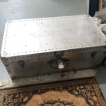 A Vintage metal travel trunk with key.