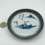 A 19th century Chinese blue and white painted pot lid fitted within a pewter surround which is
