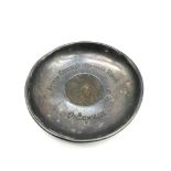 A London silver dish Holding a coin from the Khalifa's treasure house Omdurman. Silver made by