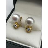 A Pair of 18ct gold earrings set with a single large pearl and single clear stone. Total weight 4.42