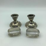 Two Birmingham silver small weighted candle sticks together with Two Birmingham silver napkin rings