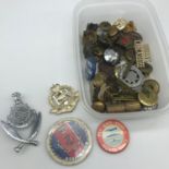 A tray of military cap badges and pin badges