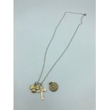 A 9ct gold necklace with three various charms, Cross, St Christopher & Shamrock, weighs 3.60grams