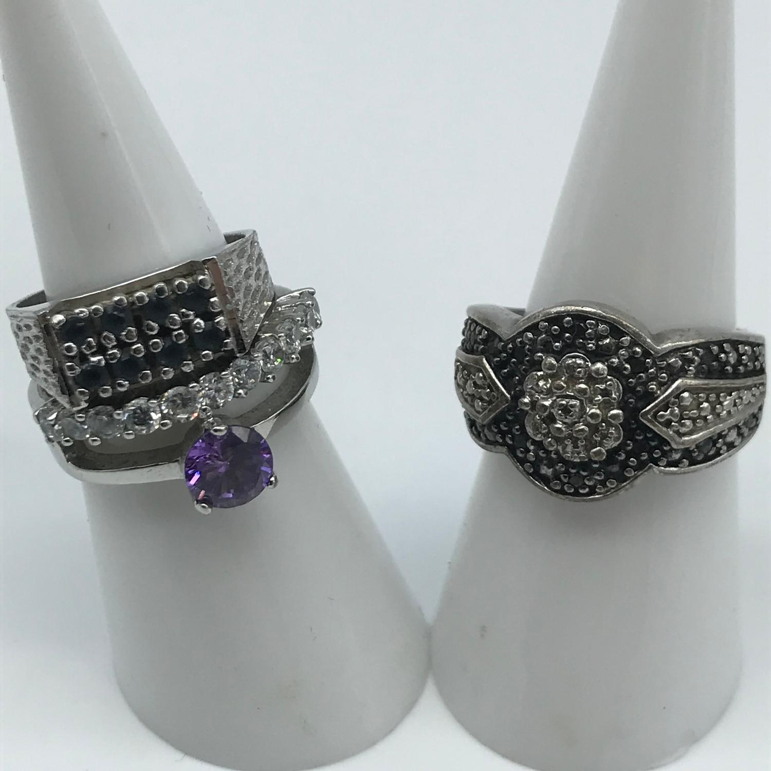 A Lot of two silver ladies rings together with one other.