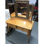 A Early 20th century light oak two drawer dressing table fitted with a gilt framed three way mirror,