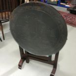 Highly carved oriental junk boar scene folding side table, fitted with a glass top.