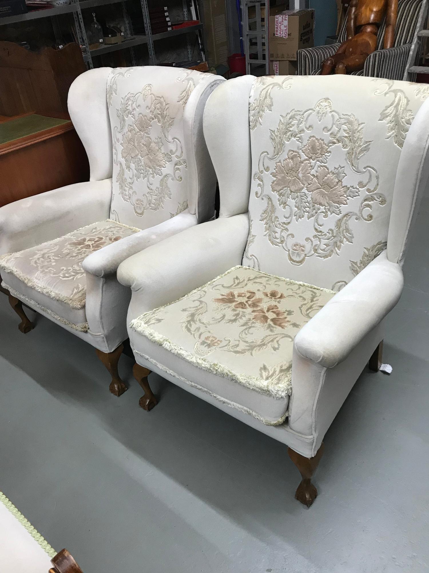 A Pair of gull wing Parker Knoll arm chairs, designed with ball and claw foot supports.