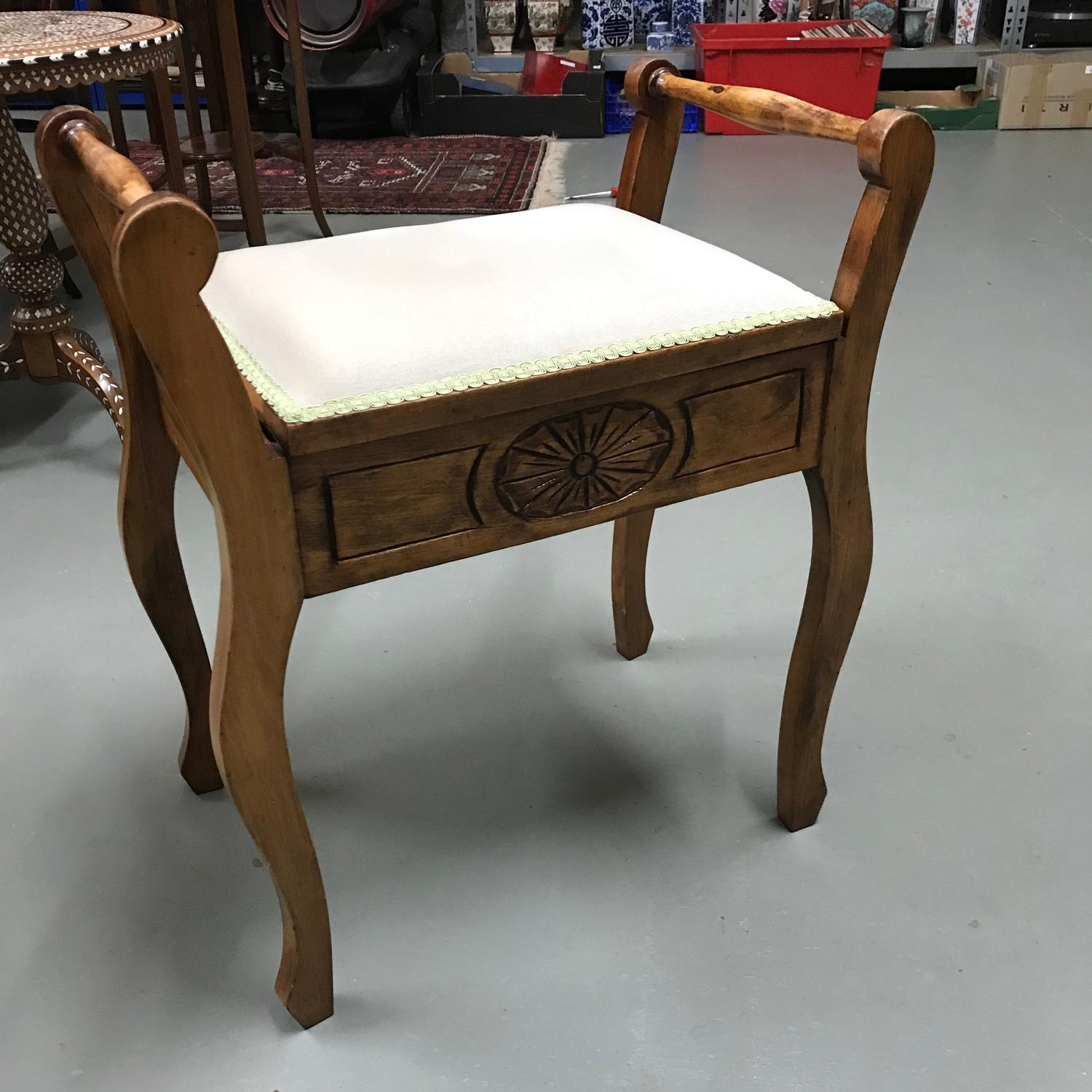 A 20th century lift top piano stool.