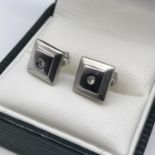 A Pair of 18ct white gold square earrings set with single diamond stones to each, Weighs 2.23grams