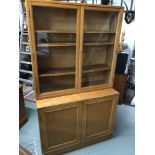 A Large Military/ School Bookcase unit, designed with two glass doors, fitted shelf interior & under