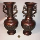 A Pair of Chinese bronze dragon handle vases. Measure 26cm in height.