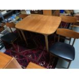 A Mid century teak extending table with 4 matching chairs