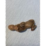 A Japanese carved netsuke frog figure. Signed by artist. Measures 4cm in length