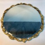 A Vintage Heavy moulded gilt framed round mirror. Measures 53cm in diameter