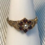 A 9ct gold garnet and single pearl ladies ring, designed with heart shaped sides. Rings size O.