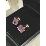 A Pair of 18ct gold ladies earrings set with Baguette cut Amethyst stones. Stone measures 7.5x6mm,