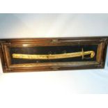 Indian gilt metal sword fitted within a glass and gilt frame display case. Sword is designed with