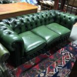 A Green leather Chesterfield three seat settee.