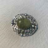 A Celtic silver thistle design brooch, set with a green single agate stone.