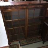 A Mahogany china cabinet designed with two glass panel doors. Supported on queen anne legs