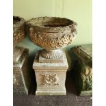 A Garden pedestal planter urn. Two Pieces. Detailed with leaf and flower design