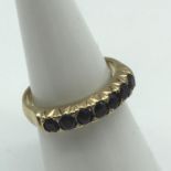 A 9ct gold ladies ring set with 7 Garnets. Ring size N. Weighs 3.30grams