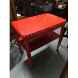A Vintage two tier trolley table painted in red giving it a retro feel.