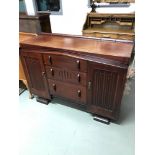 A Heavy dark wood Art Deco sideboard consists of three drawers and two doors.