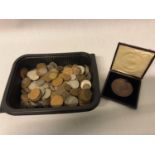 A collection of mixed coins together with a bronze medal of success awarded by the department of